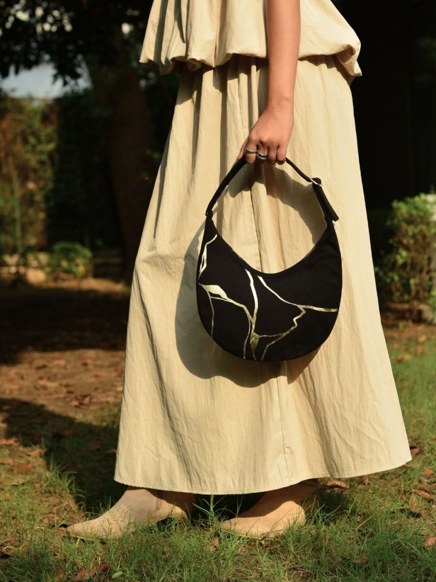 Kintsugi moon bag with artistic design worn as a shoulder bag
